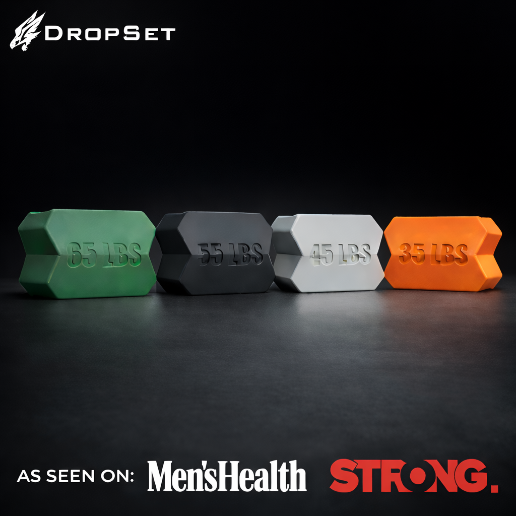 Four hexagonal weight plates in green, black, silver, and orange on a dark surface with 'DropSet' branding.