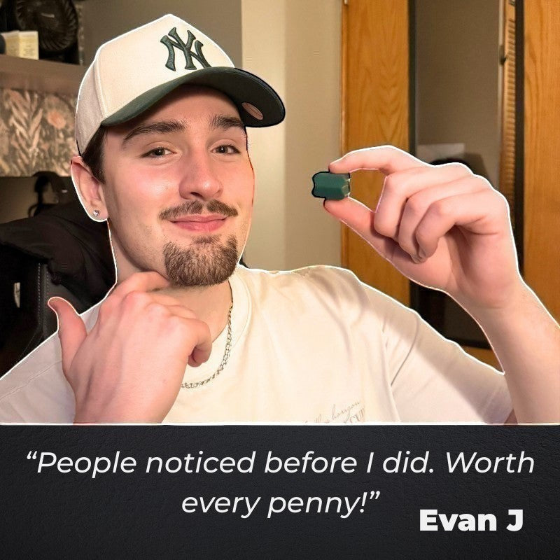 Dropset™ Official JawFlex jaw exerciser in green, held by a young man wearing a white t-shirt and a baseball cap.