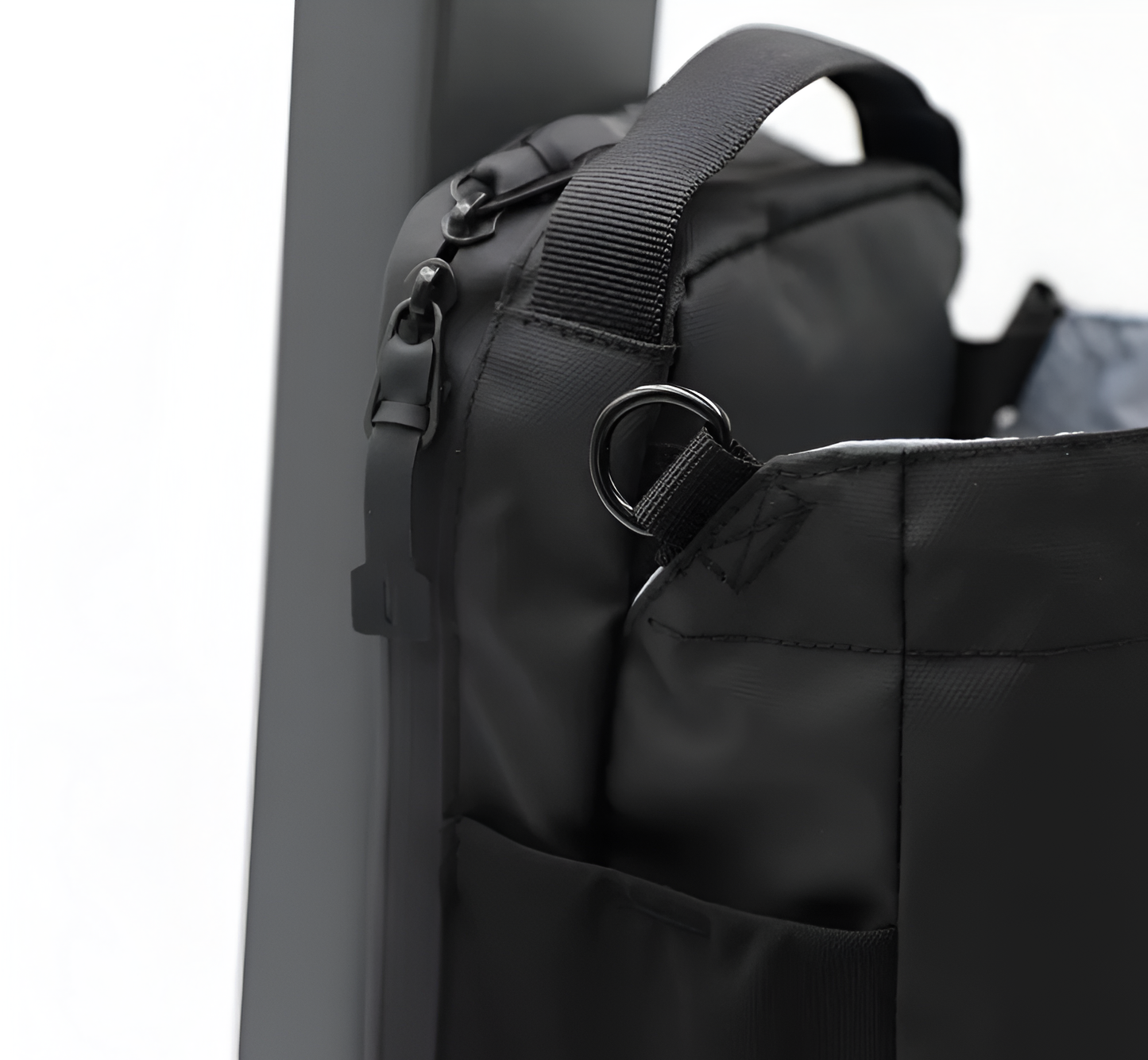 Black backpack with a strap and buckle detail on a white background