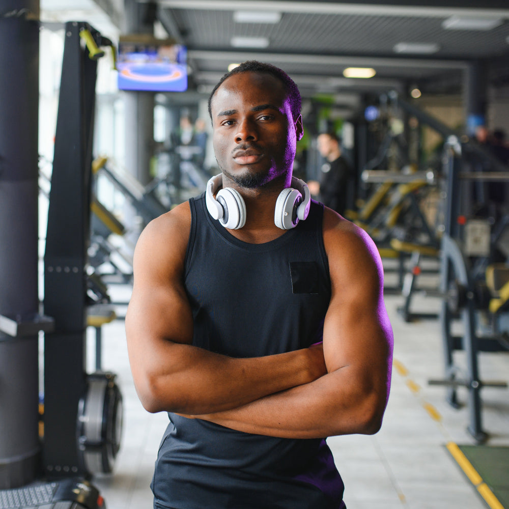 Man in a gym wearing headphones with a serious expression