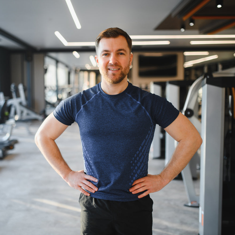 Man standing in a gym with fitness equipment in the background